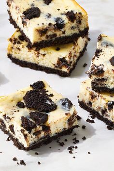 several pieces of cake with oreo cookies and cream frosting on them sitting on a white surface