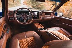 the interior of a car with brown leather seats and steering wheel, along with dashboard