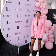 a woman standing in front of a balloon wall