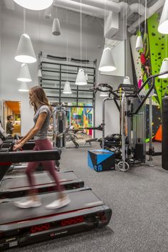 a woman running on a treadmill in a gym