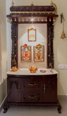 an ornate wooden cabinet with paintings on the wall