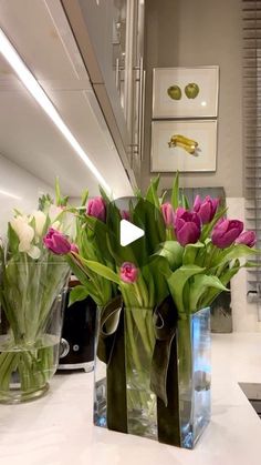 a vase filled with pink and white tulips on top of a counter