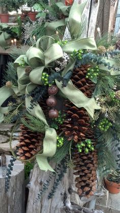 a christmas wreath with pine cones and evergreens