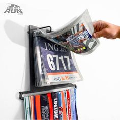 Finally, an all-in-one display for your race bibs and race medals that is sure to WOW. Our Race Medal & Bib Display turns your race bibs and medals into a work of art on your wall. Easily slide your medals onto the lower bar of the hanger and your race bibs easily hook onto the upper portion of the display. Can hold up to 24 medals and over 100 bibs. *We also recommend additional BIB PROTECTOR INSERTS for your BibFOLIO (sold separately in sets of 12): These custom BibFOLIO race bib sleeves, made Race Bib Display Diy, Running Bib Display, Race Bib Display, Race Medal Holder, Hanging Medals, Race Bib Holder, Race Medal Displays, Marathon Medal Display, Sports Medal Display