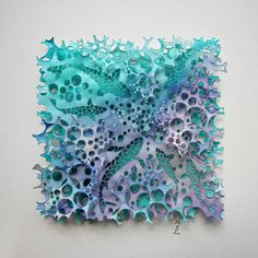 a piece of art made out of blue and purple paper with holes in the middle