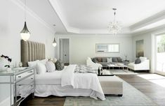 a bedroom with white furniture and chandelier