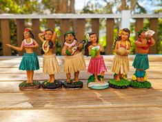 five figurines are standing on a wooden table