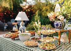 a table filled with plates and bowls of food on top of a checkered table cloth