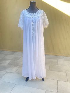 60s peignoir set with long flowy nightgown and matching sheer robe with lace details. No tags/labels. I believe this set is by Shadowline brand. All nylon. Fits like a size Medium or  Large. The nightgown has a lace, deep v-neckline with tie below the bust in the center and measures (laying flat): 18" pit to pit and 49" long. Sheer over layer with non-sheer under layer lining. The matching robe measures (laying flat): 22" pit to pit and 49" long and has two fabric covered button closures and lac Flowy Nightgown For Wedding Night, Vintage Lace Nightgown For Sleep, Vintage Daywear Robe With Lace Trim, Vintage Lace Sleepwear For Bedtime, Vintage Wedding Night Robe With Lace Trim, Vintage Sheer Nightgown For Loungewear, Vintage Sheer Lace Sleepwear, Sheer Vintage Nightgown For Loungewear, Vintage Sheer Nightgown For Sleep