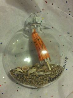 a glass ornament filled with sand and shells