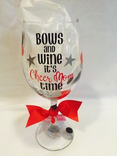 a wine glass with the words bows and wine it's cheesy mom time