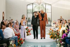 a man and woman are standing at the end of a wedding ceremony as people look on