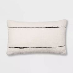 a white pillow with gold lines on the front and back, against a white background