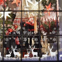 a window with christmas decorations and deers in it