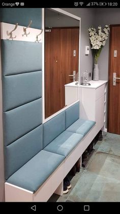 a blue bench sitting in front of a mirror on top of a wooden cabinet next to a sink