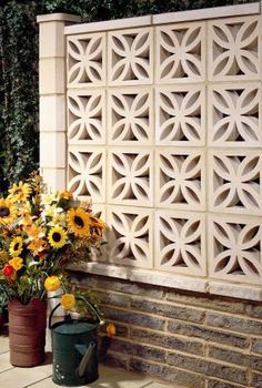 two flower pots with sunflowers in them on the side of a brick building