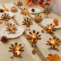 the table is set with thanksgiving decorations and candles