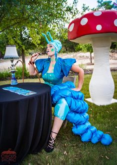 a woman sitting on top of a chair next to a mushroom