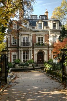 a large house with lots of trees and bushes around it's front entrance area