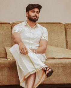 a man sitting on top of a brown couch