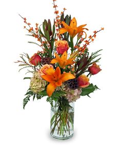 a vase filled with orange flowers and greenery