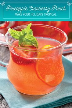 a drink in a glass on top of a blue napkin next to a bowl of fruit