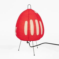 a red lamp sitting on top of a metal stand