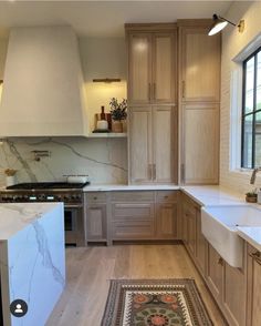 a large kitchen with wooden cabinets and marble counter tops, along with an area rug on the floor