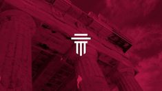 an abstract image of columns with the letter t on them against a red sky background