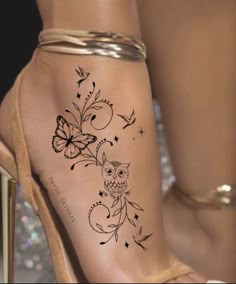 a woman's foot with an owl and butterfly tattoo on the left side of her leg