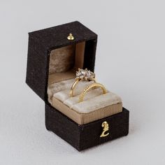 Introducing the Georgian Ring Box, a stunning homage to the classic Georgian design. Inspired by tradition, this square-shaped beauty features an exterior crafted from fine linen, exuding timeless elegance. Open it to reveal a luxurious velvet cushion, meticulously designed to put all of the attention on your ring. Choose single or double slot.  Completed with a delicate metal clasp, this heirloom-worthy ring box adds a touch of sophistication to any wedding flat lay. With a capacity to hold up to a size 12 ring, it's perfect for showcasing your treasured jewelry pieces.   With each purchase, I include an heirloom card where you can inscribe the date and the names of the bride and groom. Witness the joy as this card fills with memories over the years, creating a beautiful legacy for your l Ring Box Design, Georgian Design, Georgian Ring, Beauty Features, Georgian Era, Velvet Ring Box, Wedding Flats, Cushion Ring, Square Ring