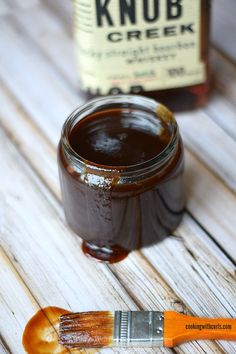 a paintbrush sitting on top of a wooden table next to a jar of ketchup