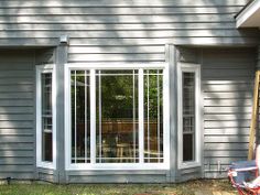 an outside view of a house that is being renovated with windows and sliding glass doors