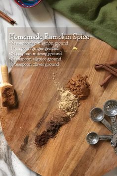 ingredients for homemade pumpkin spice sitting on a cutting board with cinnamon sticks and measuring spoons