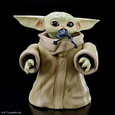 a star wars yoda figurine holding a blue object in it's hands