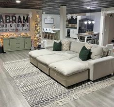 a living room filled with lots of furniture and christmas tree in the corner on the wall