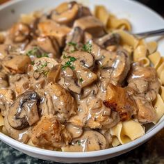 a white bowl filled with pasta covered in mushrooms