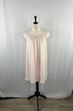 Embrace the romantic allure of bygone eras with this exquisite vintage pink chiffon nightgown, a treasure from the esteemed Shadowline collection. This nightgown is a symphony of soft pastel pink hues, crafted from airy chiffon that promises to grace your skin with a gentle caress. The neckline, a portrait of delicate sophistication, is adorned with an intricate lace overlay, embellished with dainty floral motifs and accented by petite, starry blue embellishments that capture the whimsical charm of vintage design. The gown flows in a loose, forgiving silhouette, ensuring comfort without compromising on elegance, and the hem echoes the neckline's lace details, providing a cohesive and thoughtfully designed piece. Each movement in this gown is a soft whisper, a nod to the serene and tranquil Flowy Nightgown For Wedding Night, Feminine Flowy Sleepwear, Feminine Sleepwear, Vintage Sleepwear, Pink Chiffon, Women's Nightgowns, Nightgowns, Sleepwear Pajamas, Lace Overlay