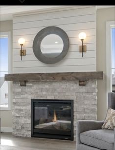 a living room with a couch, chair and fire place in front of a window