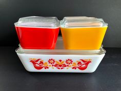 two plastic containers filled with different colored liquids on top of a counter next to each other