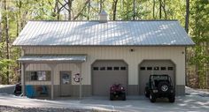 two cars are parked in front of a garage that is built into the side of a wooded area