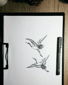 two birds flying next to each other on top of a white paper with black ink