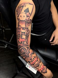 a person sitting in a chair with a tattoo on their arm