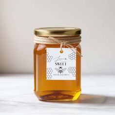 a glass jar filled with honey sitting on top of a table