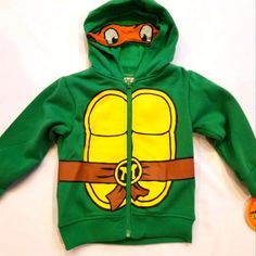 Teenage Mutant Ninja Turtles Hoodie Coat Jacket. Size 2t Cotton/Polyester Stylish Hoodie With Super Cute Tmnt Design On Front, Back And Hood. Hood Zip-Up Front For Easy Access Perfect For Dress-Up And Every Day Wear Machine Wash Cold; Officially Licensed Comes From A Pet And Smoke Free Home. Yellow Spring Hoodie Outerwear, Playful Hoodie Outerwear For Winter, Playful Winter Hoodie Outerwear, Winter Long Sleeve Hoodie For Playwear, Cotton Long Sleeve Outerwear For Play, Long Sleeve Cotton Outerwear For Play, Hooded Hoodie For Playwear In Fall, Hooded Outerwear With Drawstring Hood For Playtime, Winter Hooded Sweatshirt For Playwear