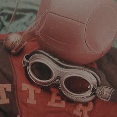 a pair of goggles sitting on top of a red shirt next to a soccer ball