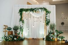 an indoor wedding setup with white drapes and greenery