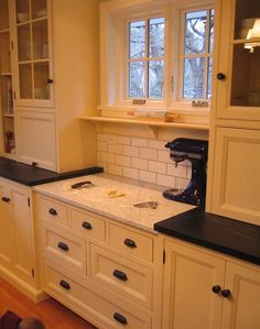 a kitchen with white cabinets and black counter tops