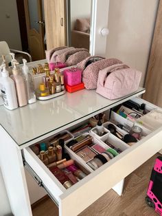 an organized vanity with makeup and toiletries on the top shelf, in front of a mirror