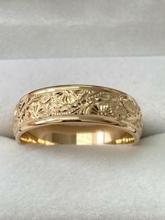 a yellow gold wedding band with an intricate design